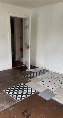 an empty room with wooden floor and entrance