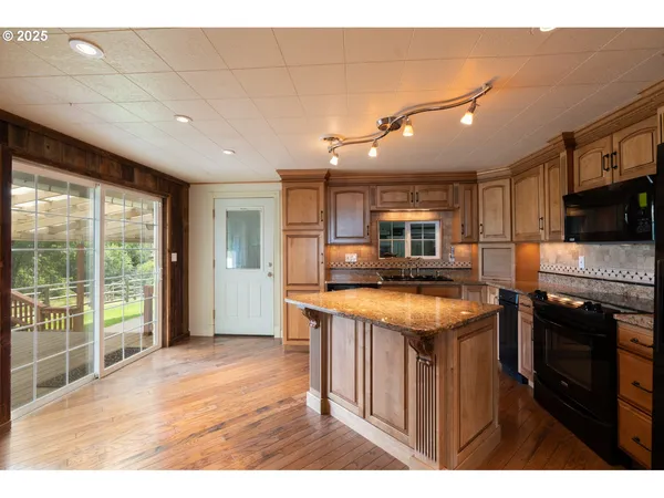 a open kitchen with stainless steel appliances granite countertop a refrigerator and a stove