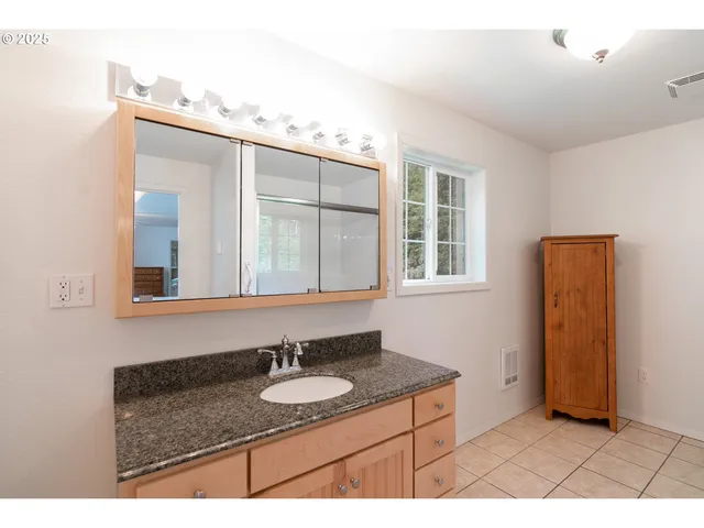a bathroom with a granite countertop sink and a mirror
