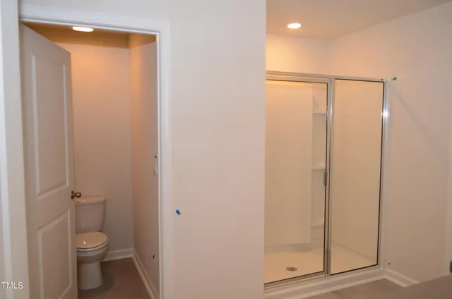 a bathroom with a granite countertop toilet and a shower
