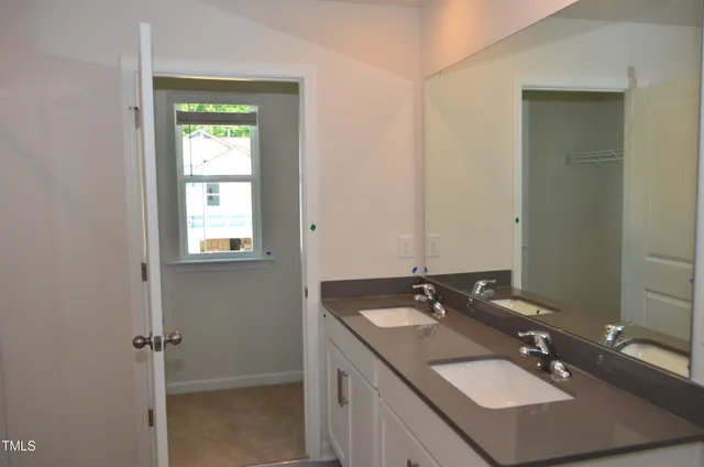 a bathroom with a sink double vanity and a mirror