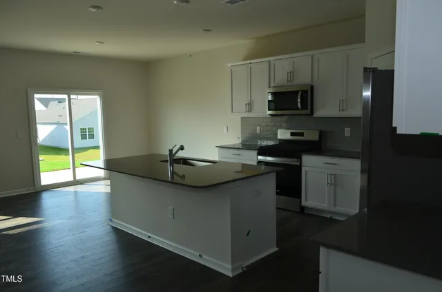 a kitchen with stainless steel appliances a sink stove and microwave
