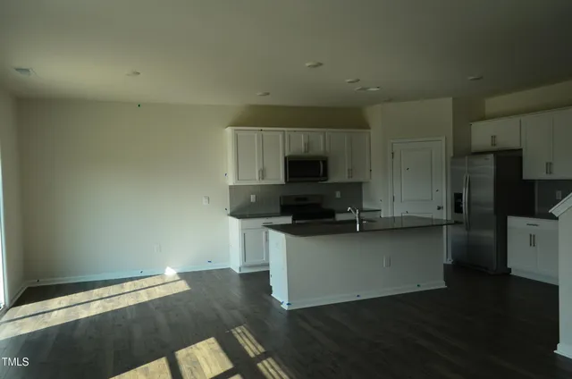 a kitchen with granite countertop white cabinets and black appliances