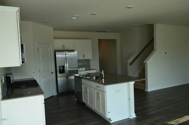 a kitchen with a refrigerator and a stove top oven