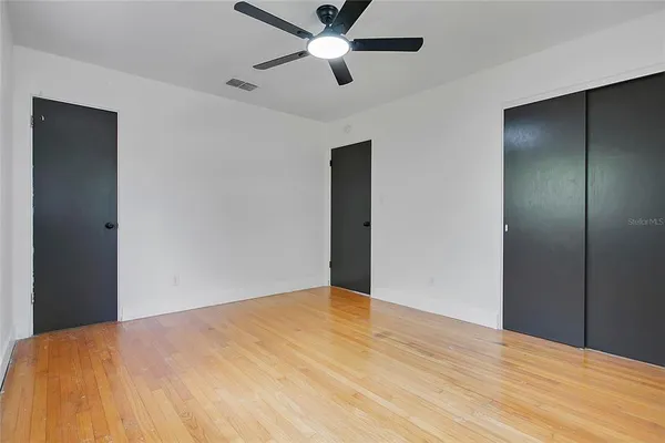 a view of empty room with wooden floor