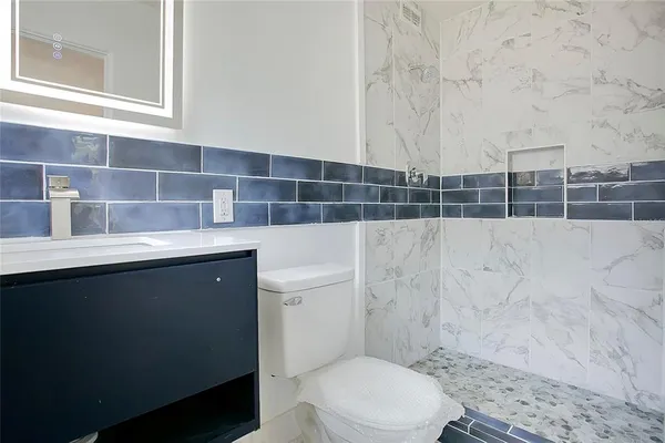 a bathroom with a sink a toilet and a mirror