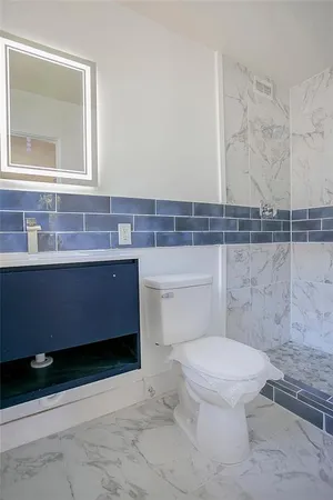 a bathroom with a toilet a sink and mirror