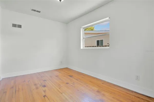 a room with a wooden floor and a window