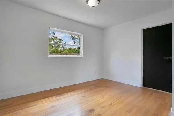 a view of an empty room with wooden floor