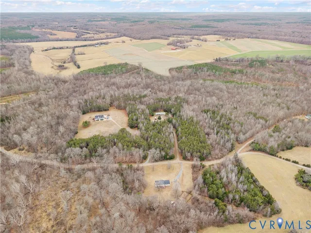 an empty room with windows a fireplace and wooden floor