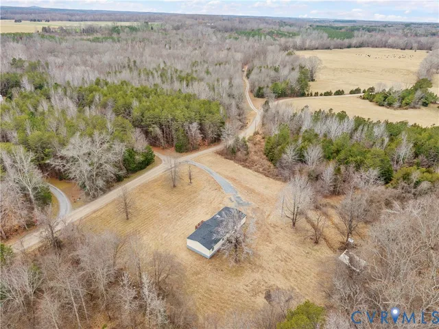 a view of an empty room with wooden floor fireplace and a window