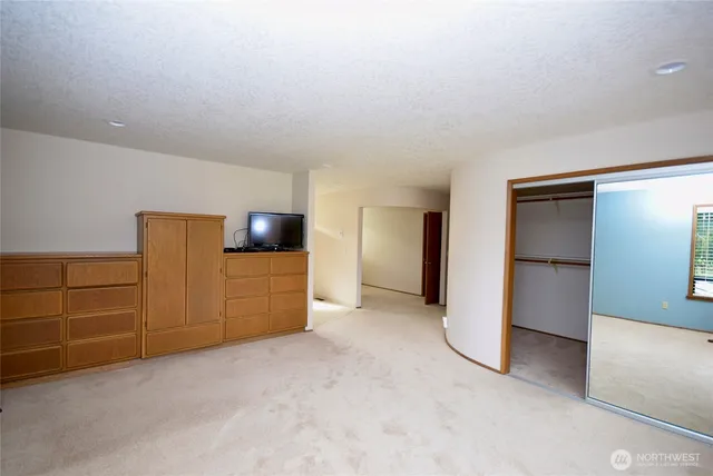 an empty room with a cabinet and mirrors
