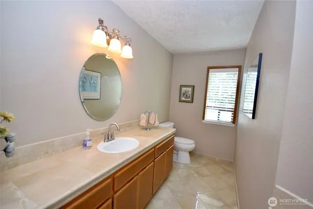 a en suite bathroom with a double vanity sink mirror and a toilet