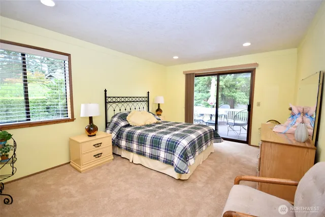 a bedroom with a bed and large windows