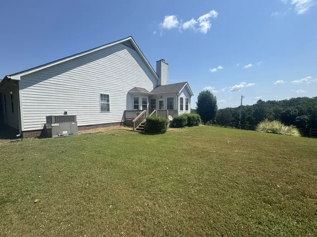 a view of a house with a yard and potted plants