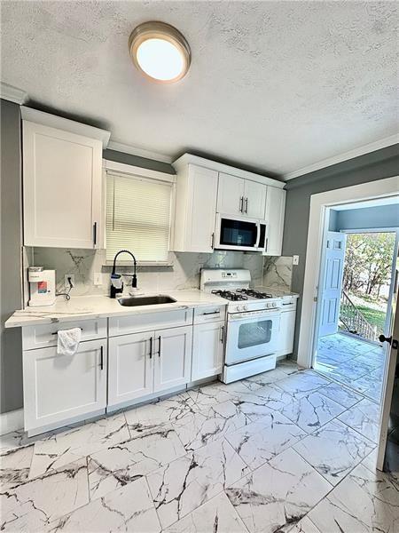 94 Lafferty Avenue Pittsburgh, PA 15210 - Photo 12 of 17 a kitchen with stainless steel appliances a stove sink and microwave