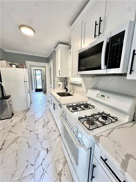 94 Lafferty Avenue Pittsburgh, PA 15210 - Photo 13 of 17 a kitchen with stainless steel appliances a stove microwave and sink