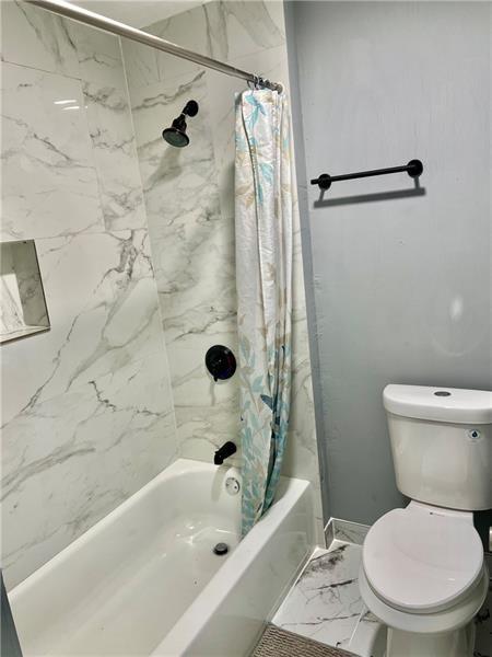 94 Lafferty Avenue Pittsburgh, PA 15210 - Photo 8 of 17 a white toilet sitting next to a bath tub and a shower