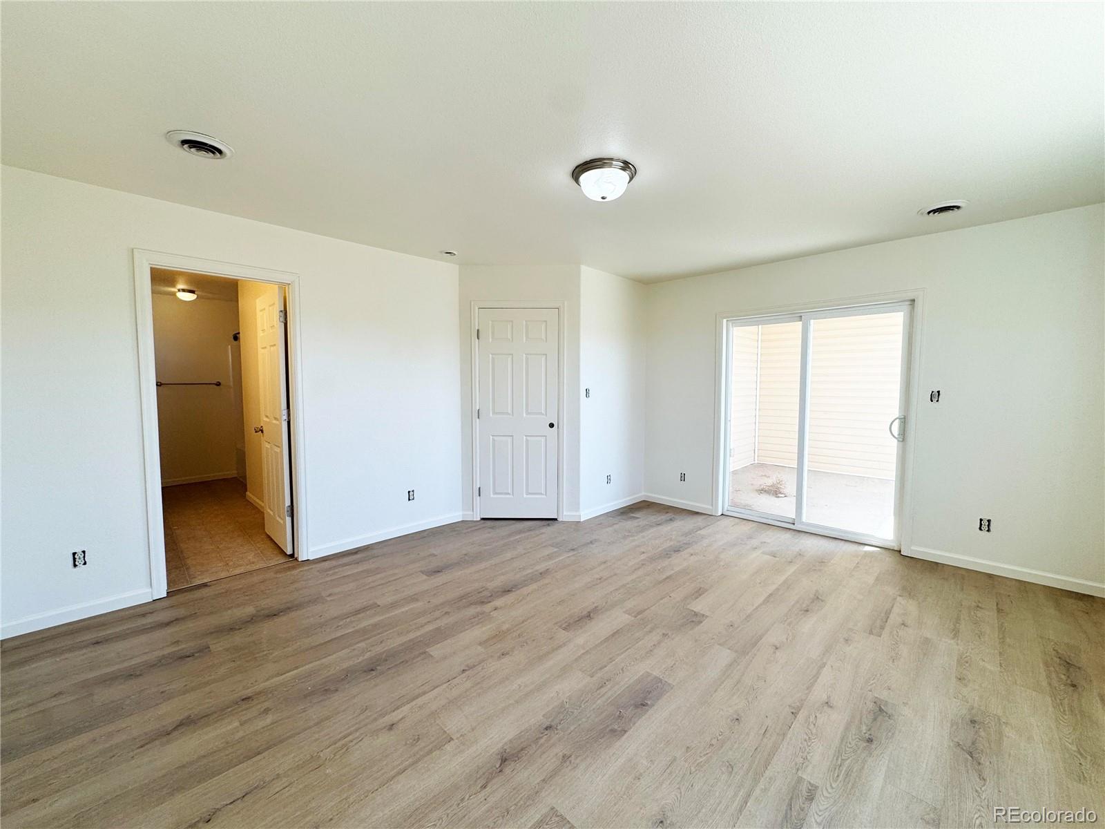 1041 Halfturn Road Rangely, CO 81648 - Photo 7 of 11 an empty room with wooden floor & windows