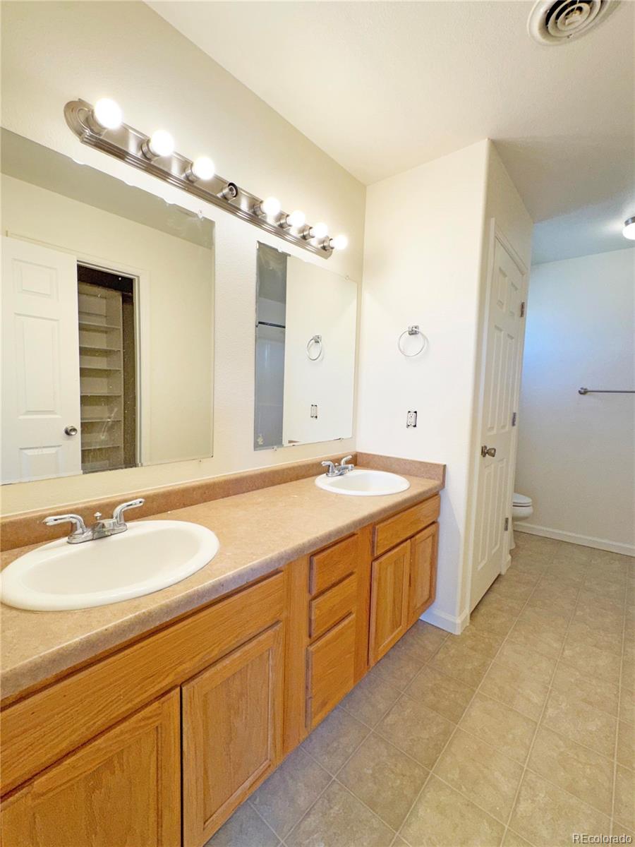 1041 Halfturn Road Rangely, CO 81648 - Photo 8 of 11 a spacious bathroom with a granite countertop double vanity sink a mirror and a bathtub
