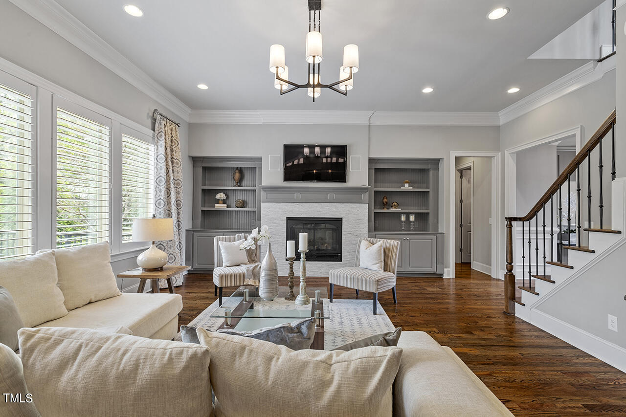 3601 Laurel Hills Road Raleigh, NC 27612 - Photo 26 of 77 a living room with furniture a fireplace a flat screen tv and a large window