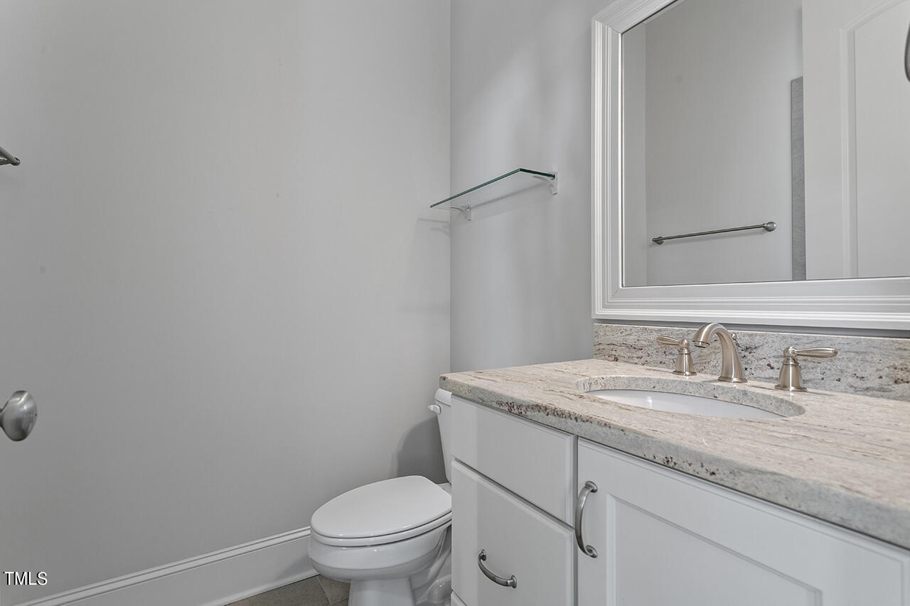 3601 Laurel Hills Road Raleigh, NC 27612 - Photo 51 of 77 a bathroom with a granite countertop toilet sink and mirror