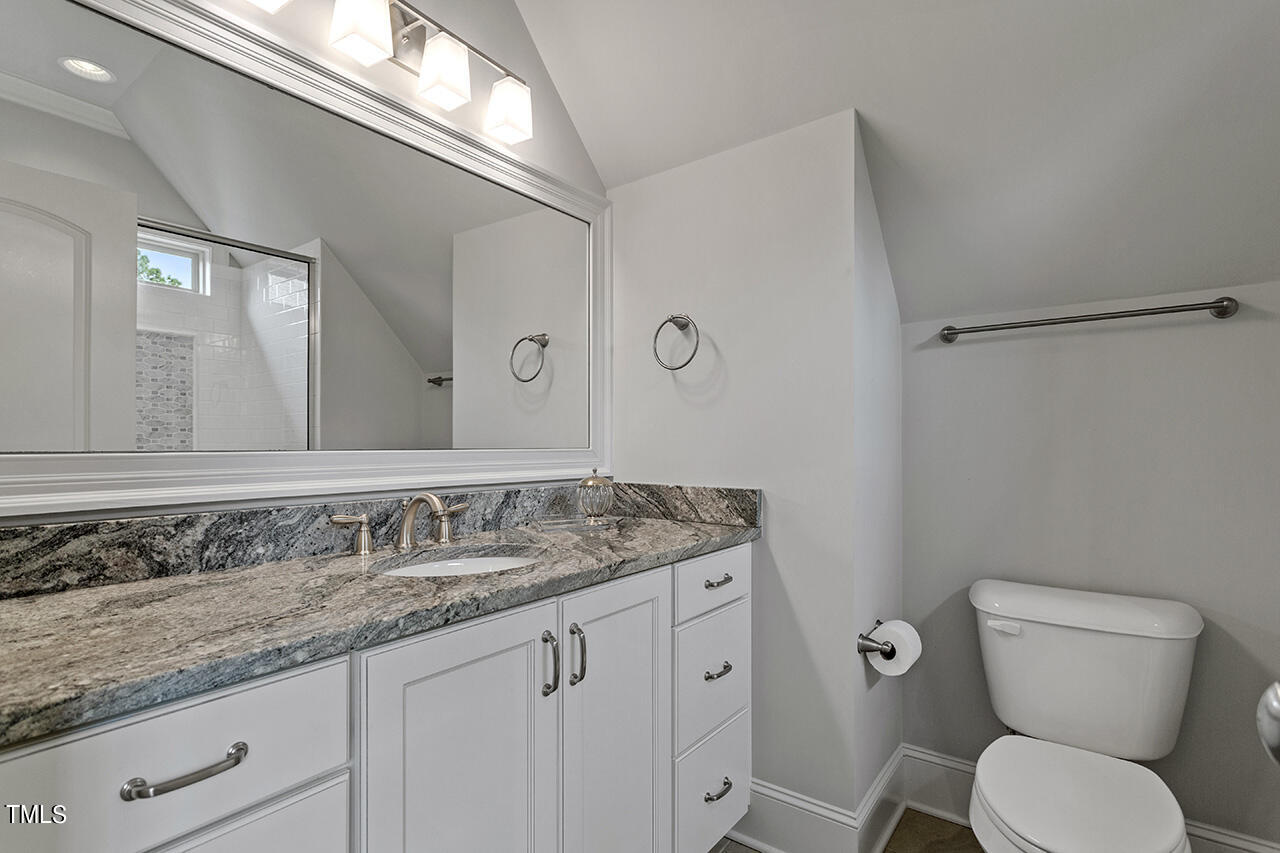3601 Laurel Hills Road Raleigh, NC 27612 - Photo 55 of 77 a bathroom with a granite countertop toilet sink and mirror
