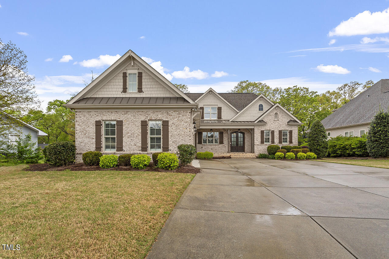 3601 Laurel Hills Road Raleigh, NC 27612 - Photo 6 of 77 a front view of a house with a yard and garage
