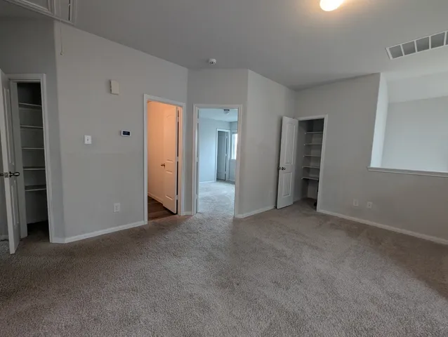 an empty room with closet and wooden door