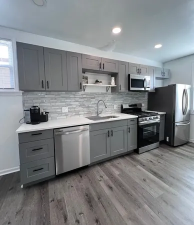a kitchen with stainless steel appliances granite countertop a stove a sink dishwasher and a refrigerator