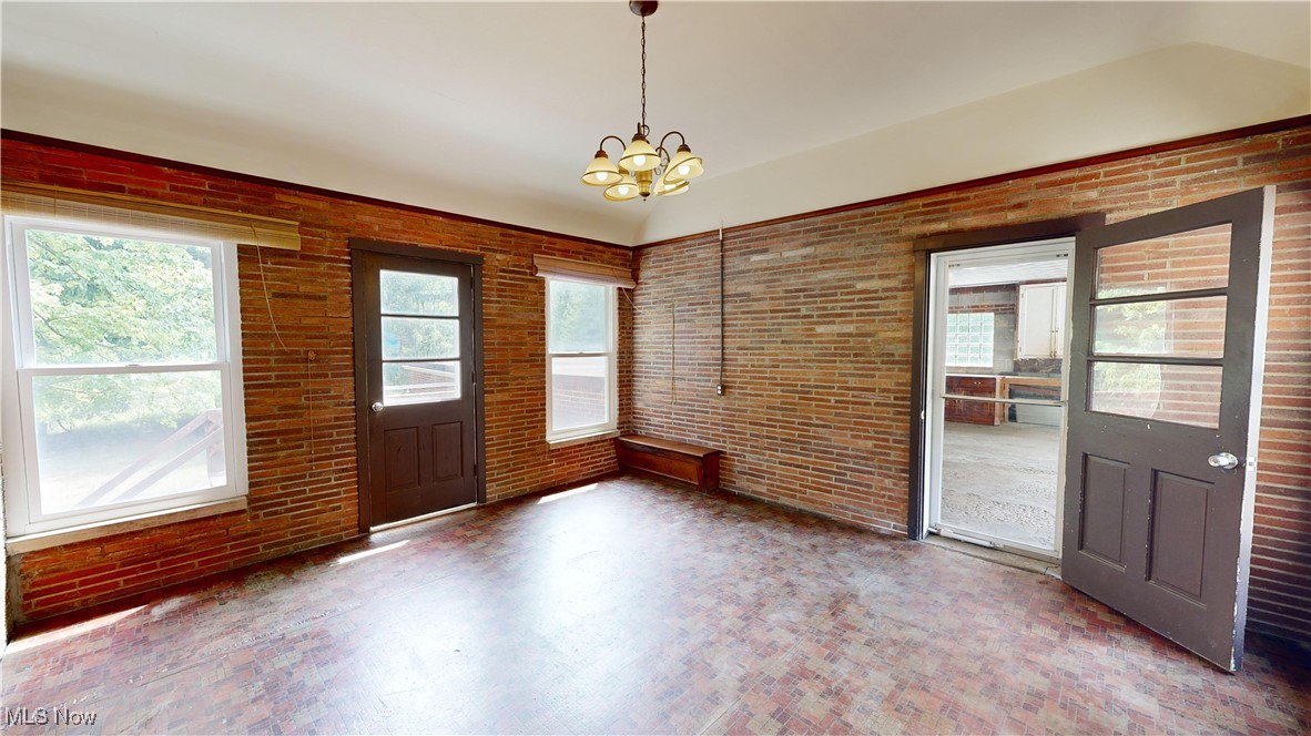 29280 White Road Wickliffe, OH 44092 - Photo 22 of 43 Family room with brick wall and a notable chandelier