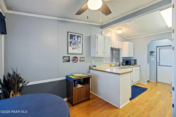 a kitchen with granite countertop a sink cabinets stainless steel appliances and a potted plant
