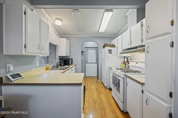 a kitchen with stainless steel appliances granite countertop a sink a stove and refrigerator