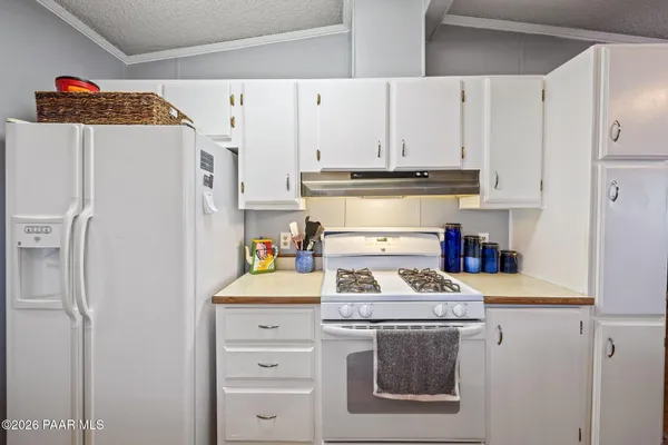 a kitchen with stainless steel appliances granite countertop a refrigerator and a stove