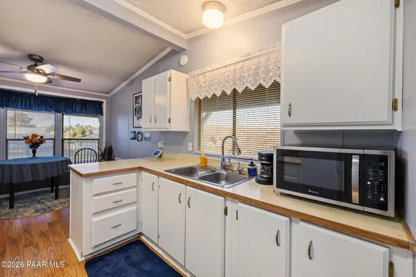 a kitchen with white cabinets and window