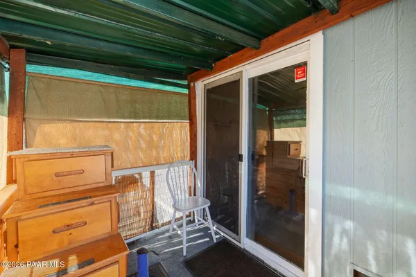 a view of a door and chair under an umbrella