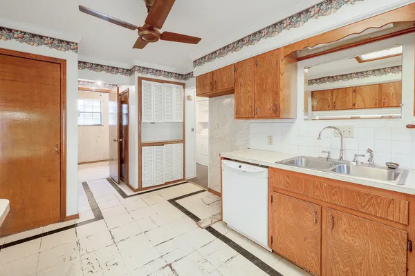 a kitchen with sink a refrigerator and white cabinets