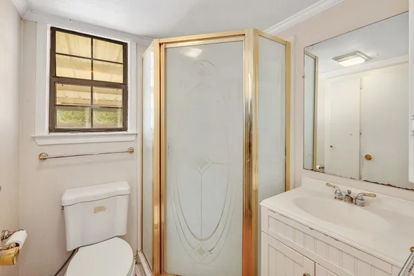 a bathroom with a sink a toilet and shower
