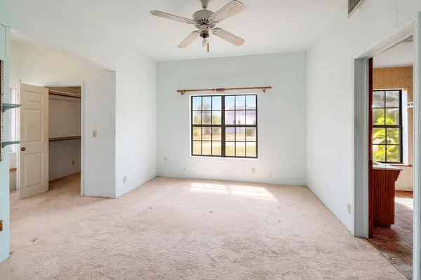 an empty room with windows and cabinet