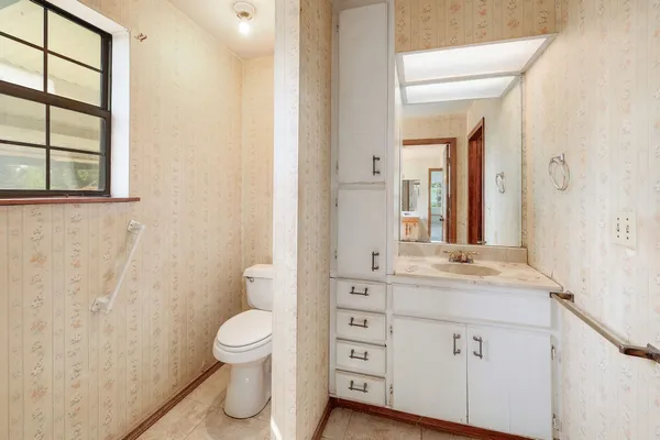 a bathroom with a toilet sink and mirror