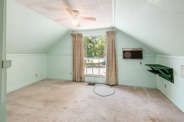 a view of a livingroom with a window and kitchen view
