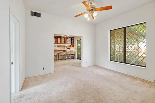an empty room with windows and fan