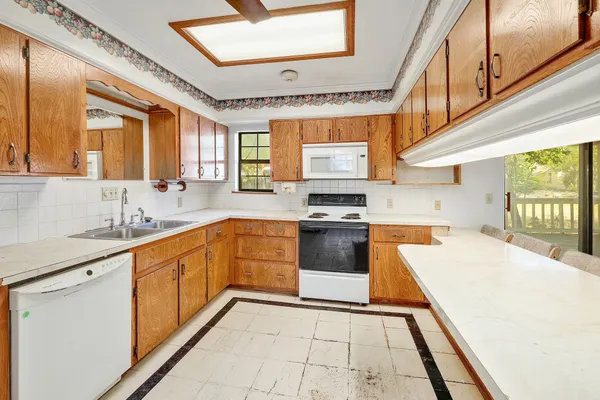 a large white kitchen with stainless steel appliances and a sink