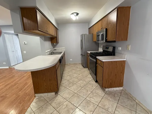 a kitchen with stainless steel appliances a sink a stove a refrigerator a microwave oven and cabinets