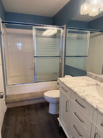 a bathroom with a granite countertop sink toilet and shower