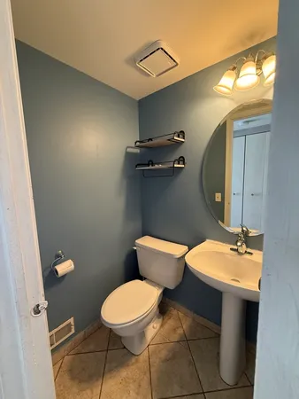 a bathroom with a toilet sink and mirror