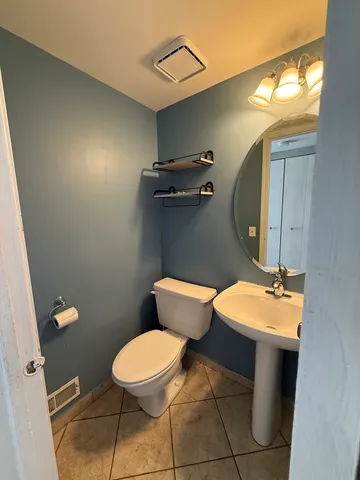 a bathroom with a toilet a sink and mirror