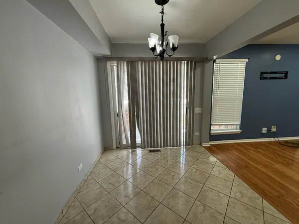 a view of a livingroom with a chandelier fan and windows