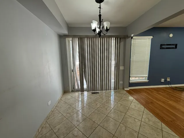 a view of a livingroom with a chandelier fan and windows
