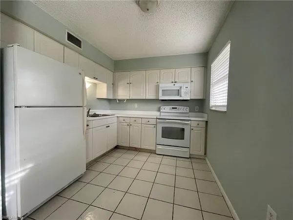 a kitchen with white cabinets stainless steel appliances and a sink
